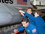 Space shuttle wing leading edge is being inspected by STS-114 return to flight crew.