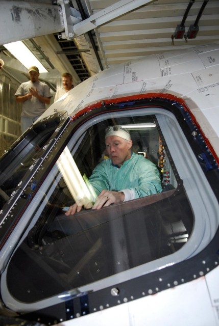 In the Orbiter Processing Facility at NASA's Kennedy Space Center, space shuttle Endeavour's STS-123 Commander Dominic Gorie inspects the window in space shuttle Endeavour. The crew is at Kennedy for crew equipment interface test, a process of familiarization with payloads, hardware and the space shuttle. The STS-123 mission is targeted for launch on Feb. 14. It will be the 25th assembly flight of the station. Photo credit: NASA/Kim Shiflett