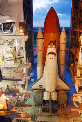 Workers monitor the progress of Space Shuttle Discovery as it moves through the doors of the Vehicle Assembly Building toward Launch Pad 39A.