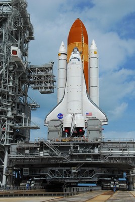 Access platforms at Launch Pad 39A are moved into position against Space Shuttle Discovery atop a mobile launch platform.