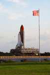 Space Shuttle Discovery moves along the crawlerway near the turn basin in Launch Complex 39 toward Pad A as the sun rises on a balmy Florida morning.