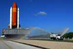 A rainbow can be seen in the spray from the water truck traveling ahead of Space Shuttle Discovery on its move from the Vehicle Assembly Building to Launch Pad 39A.