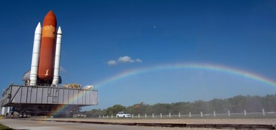 A rainbow can be seen in the spray from the water truck traveling ahead of Space Shuttle Discovery on its move from the Vehicle Assembly Building to Launch Pad 39A.